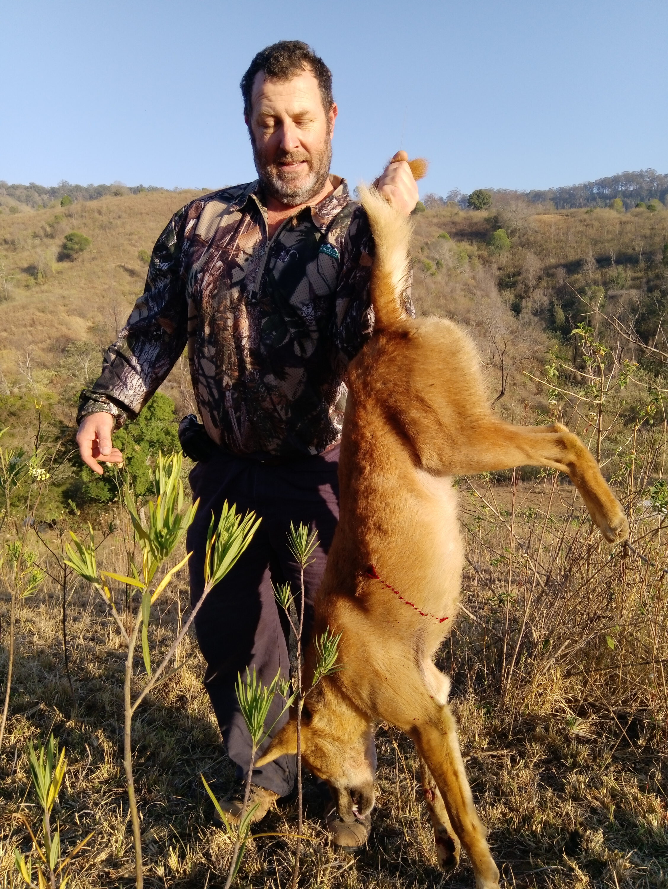 Darryn holding up his first wild dog.