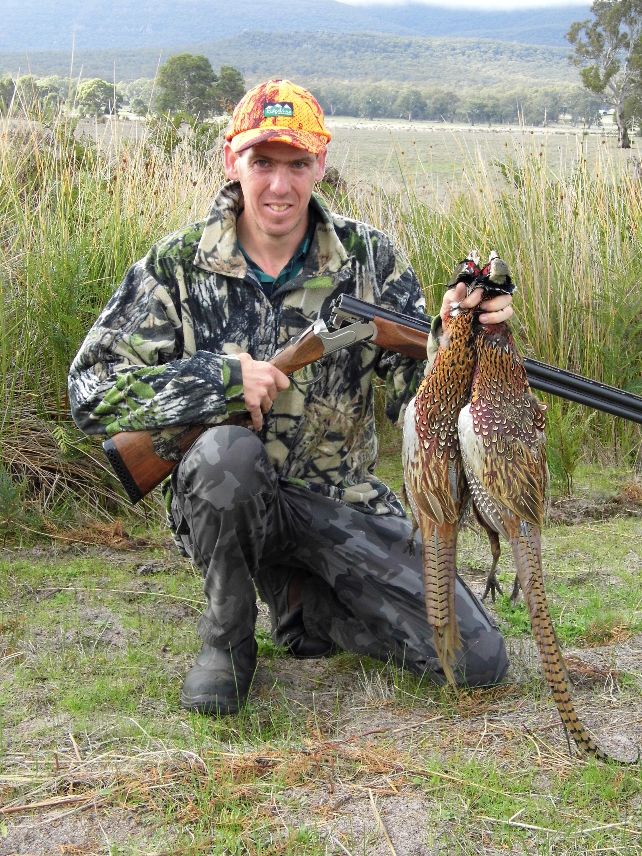 Blake proudly displaying two cock pheasant that fell to his under and over shotgun after being flushed by Dax, the GSP.